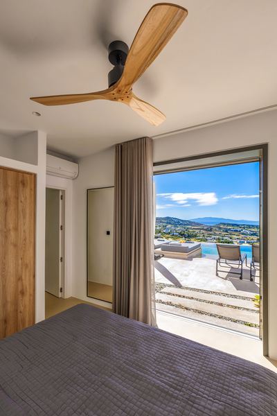 Bedroom with ceiling fan and sea-view terrace access