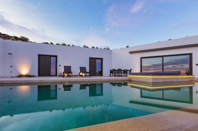 Pool terrace at dusk, lit for the evening