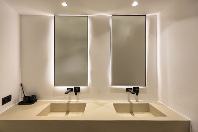 Double-vanity bathroom with backlit mirrors