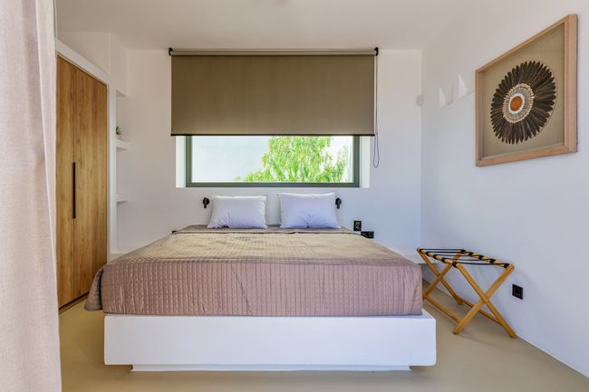 Bedroom with roller blind and sea-facing window